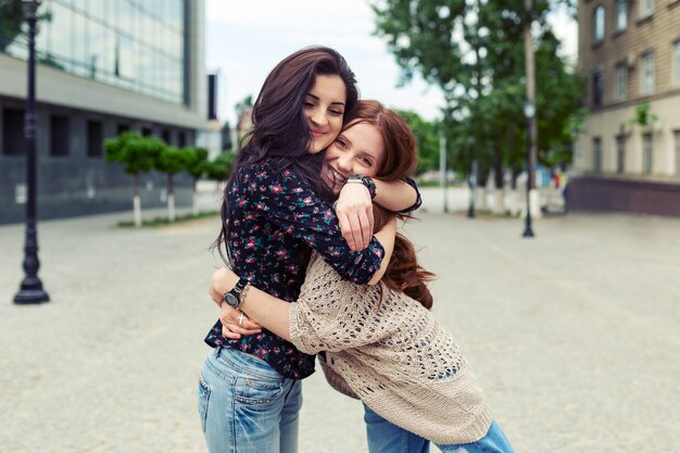 Carefree smiling sisters hugging and having fun together