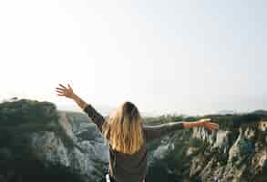 Free photo carefree woman arms outstretched on the mountain