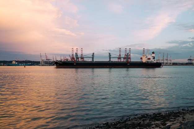 Free Photo cargo ship parked at the harbor on a sunny day during sunset