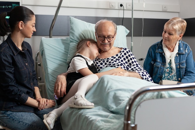 Caring grandchild hugging sick elderly grandparent showing love