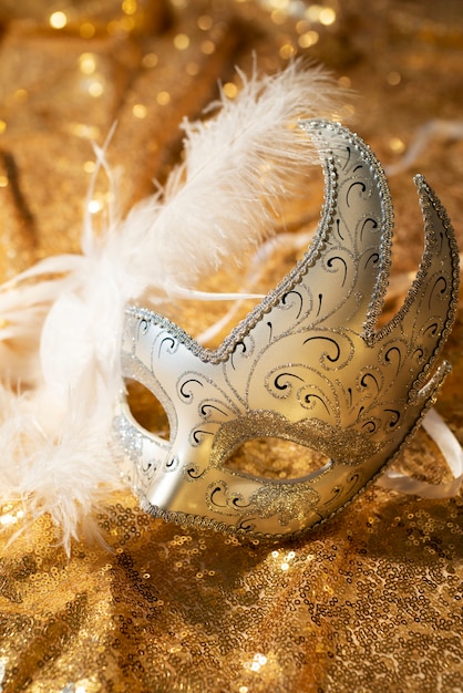 Free photo carnival mask on golden textile