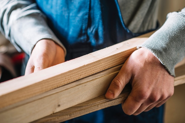 Free photo carpenter carrying wood