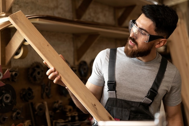 Free photo carpenter cutting mdf board inside workshop