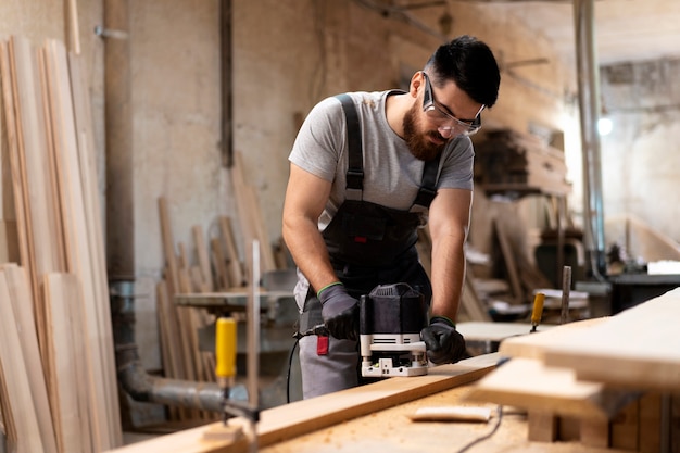 Carpenter cutting mdf board inside workshop