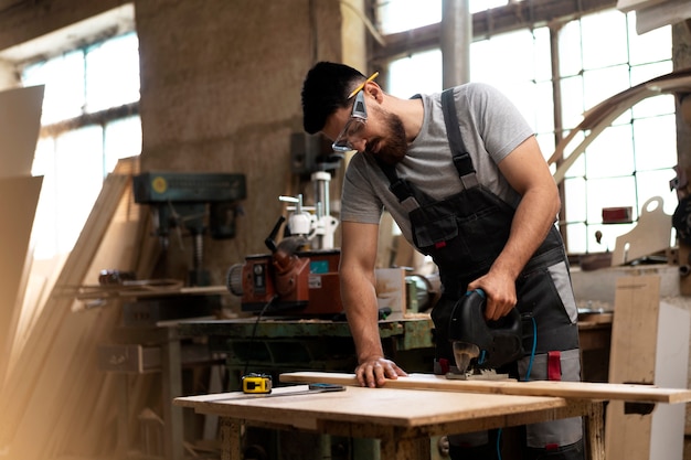 Carpenter cutting mdf board inside workshop