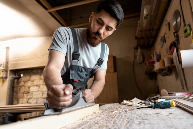 Carpenter cutting mdf board inside workshop