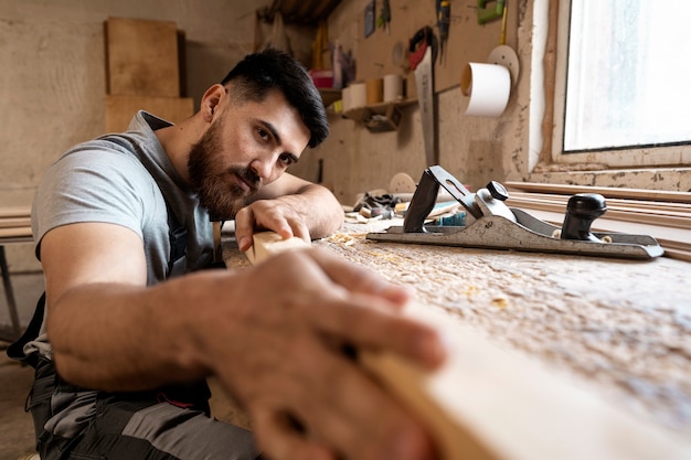 Free photo carpenter cutting mdf board inside workshop