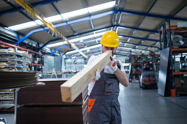 Free photo carpenter production line worker checking wood material for furniture production in factory hall