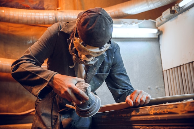 Carpenter using circular saw for cutting wooden boards. Construction details of male worker or handy man with power tools