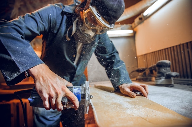 Free photo carpenter using circular saw for cutting wooden boards. construction details of male worker or handy man with power tools