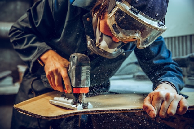 Carpenter using circular saw for cutting wooden boards.