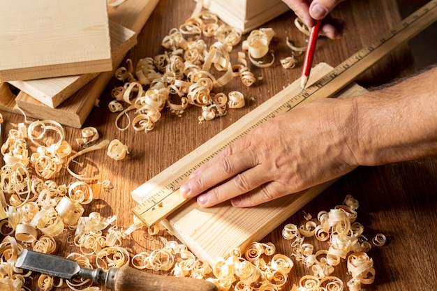 Carpenter working on a piece of wood with pencil