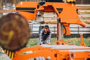 Free photo carpenter working on a sawmill on a wood manufacture