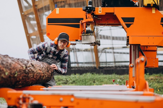 Free photo carpenter working on a sawmill on a wood manufacture