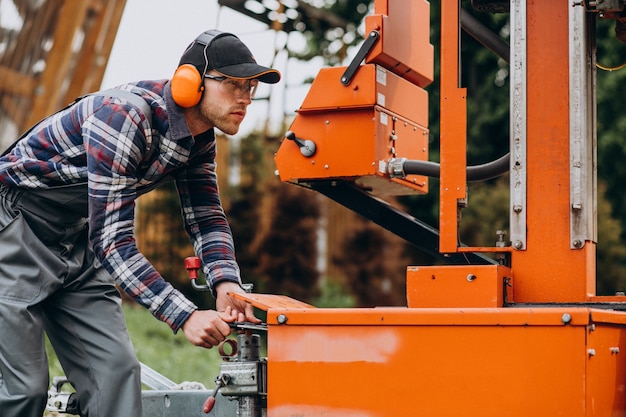 Free photo carpenter working on a sawmill on a wood manufacture