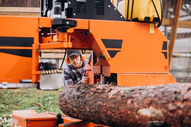 Free photo carpenter working on a sawmill on a wood manufacture