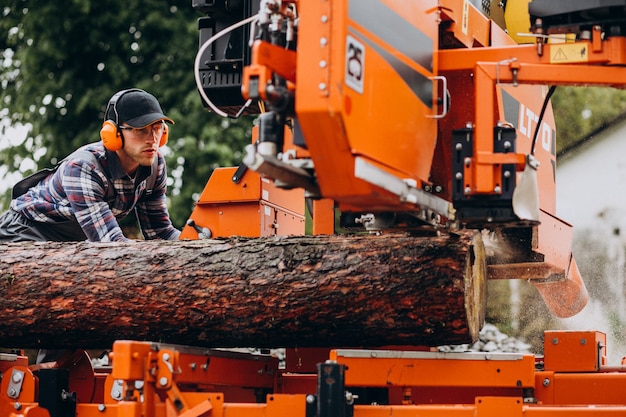 Free photo carpenter working on a sawmill on a wood manufacture