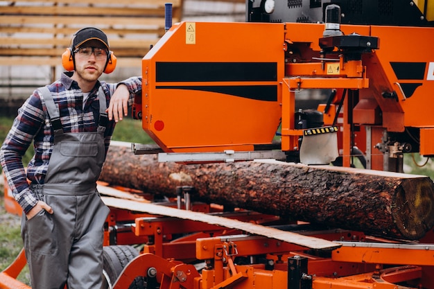 Free Photo carpenter working on a sawmill on a wood manufacture