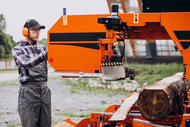 Free photo carpenter working on a sawmill on a wood manufacture