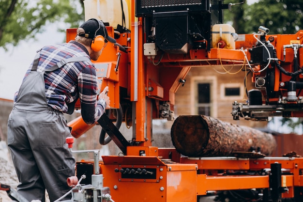 Free photo carpenter working on a sawmill on a wood manufacture