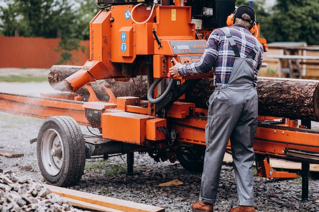 Free photo carpenter working on a sawmill on a wood manufacture