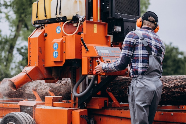 Free photo carpenter working on a sawmill on a wood manufacture