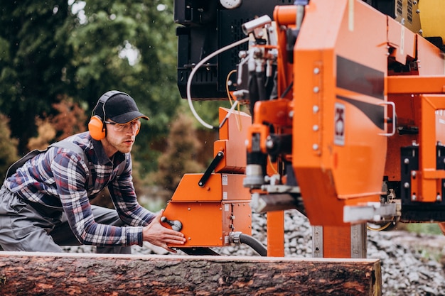 Free Photo carpenter working on a sawmill on a wood manufacture