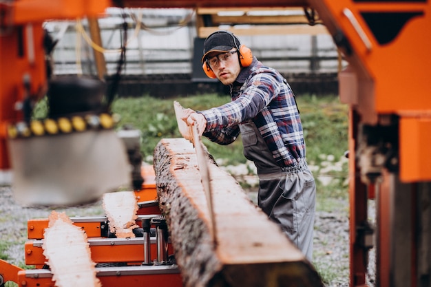 Carpenter working on a sawmill on a wood manufacture