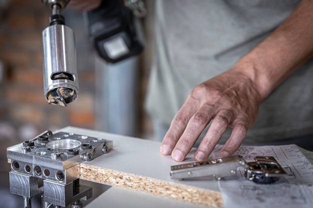 The carpenter works with a professional precision drilling tool.