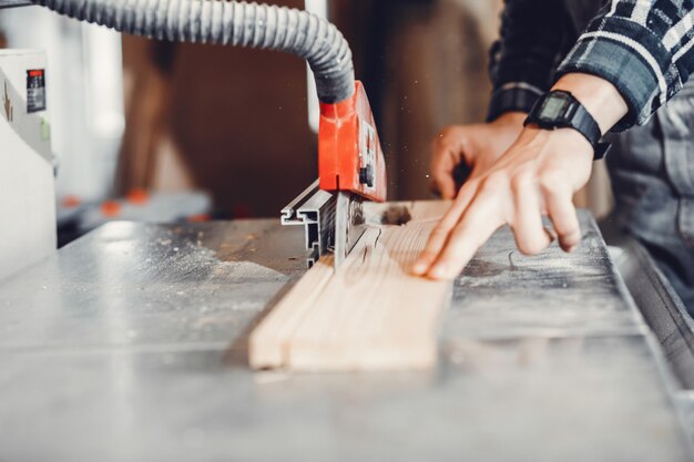 The carpenter works with a tree