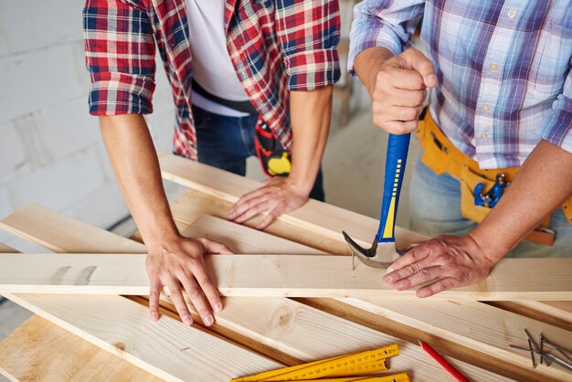 Carpenters removing nails from wood