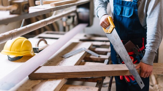 Carpentry concept with man working with saw