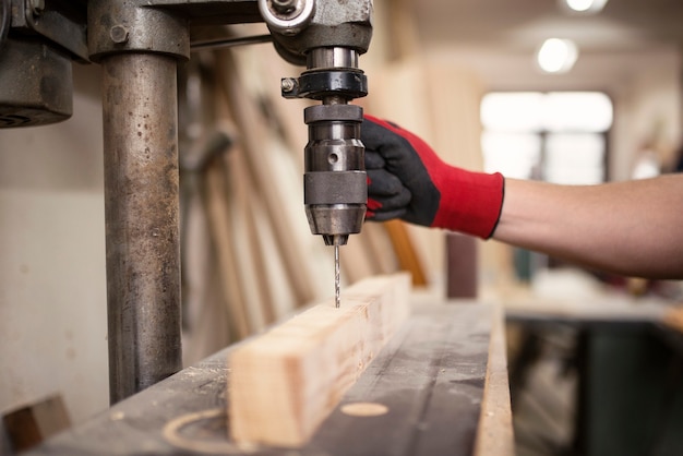 Free photo carpentry workshop and drilling machine working on a piece of wood material