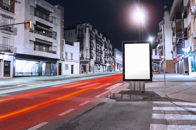 Free photo cars light trails passing near the blank billboard on sidewalk in the city