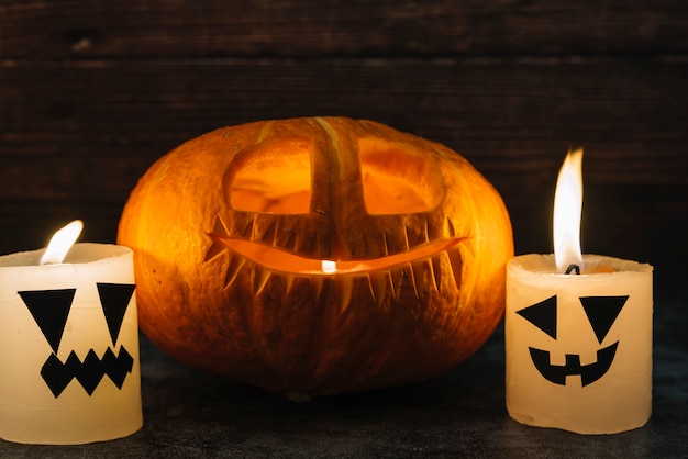 Free photo carved halloween jack-o-lantern and candles on table