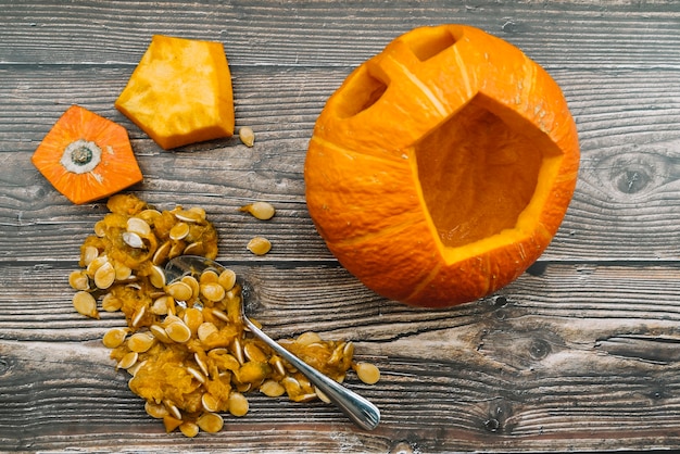 Free Photo carved halloween pumpkin with pepitas on wooden background