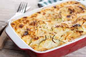 Free photo casserole with cheese and gratin zucchini on wooden table