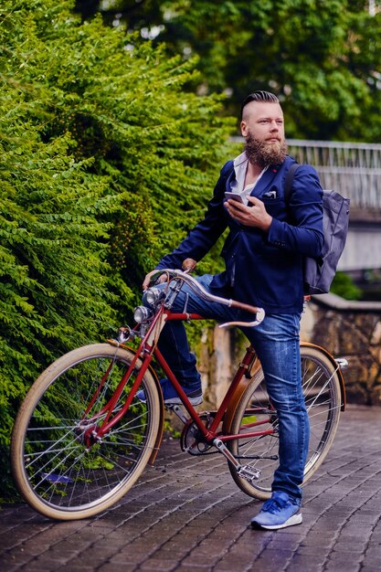 Casual bearded male in a park talks by smart phone.