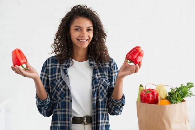 Casual dressed woman holding red peppers