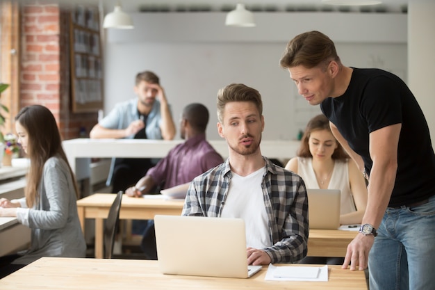 Free photo casual entrepreneur explaining business project to his coworker.