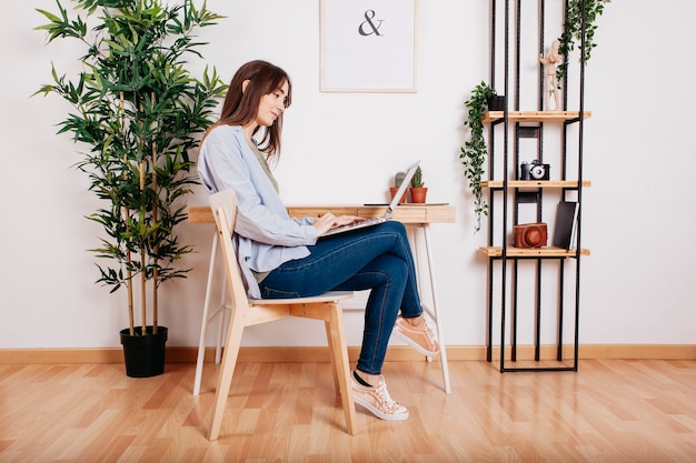 Free photo casual girl surfing laptop at home