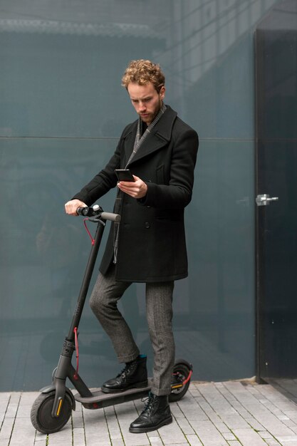 Casual male posing with an electric scooter