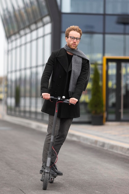 Casual male posing with an electric scooter