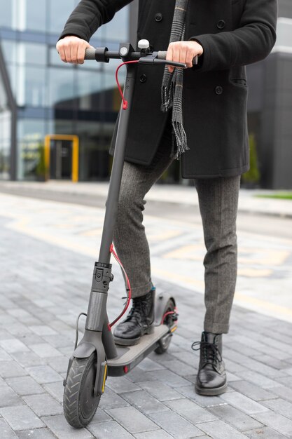 Casual male posing with his electric scooter