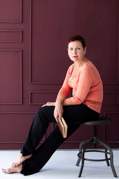 Casual mature woman sitting on a stool