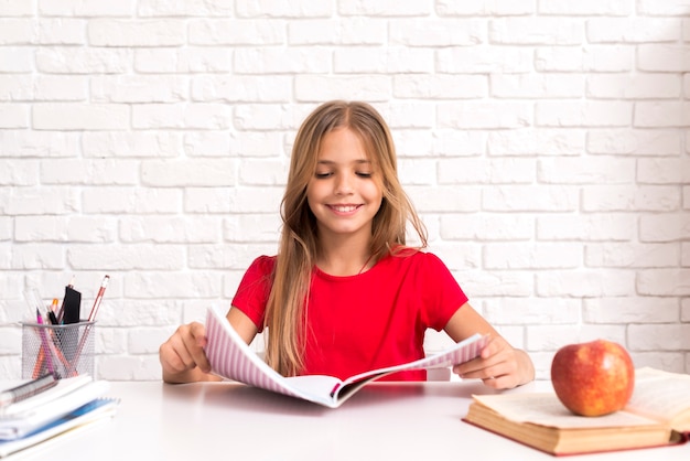 Free photo casual schoolgirl reading workbook