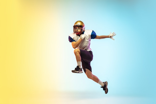 Free photo catching. american football player isolated on gradient in neon light.