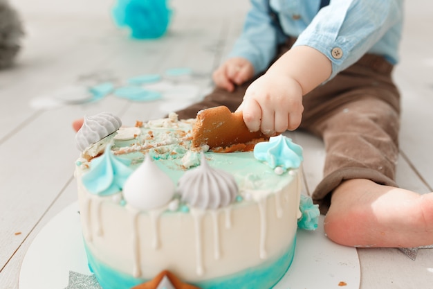 caucasian birthday boy legs and arms while he destroys and smashes his cream cake 