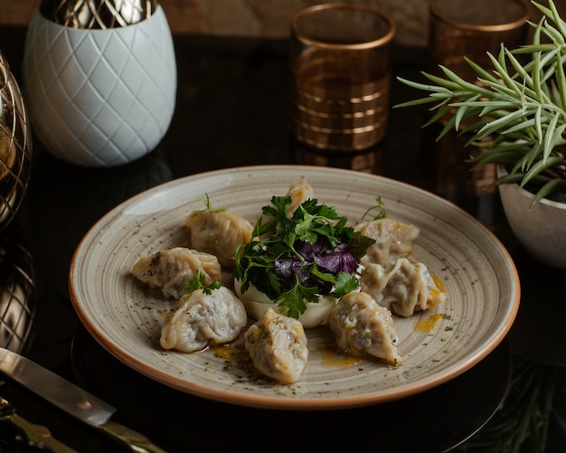 Free photo caucasian delicious food khinkali, khingal finely cooked and served with fresh parsley and red basilica leaves