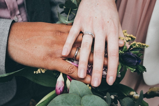 Free Photo a caucasian female and african american male wearing rings and holding flowersdiversity concept